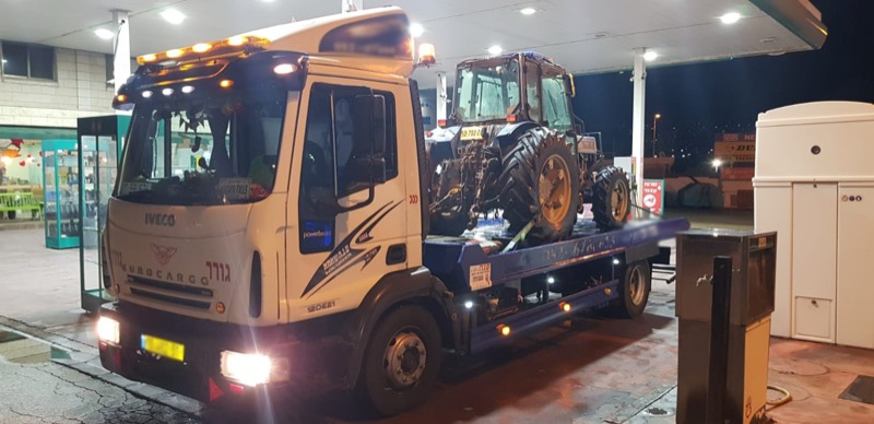 משאית גרר מובילה טרקטור בתוך מבנה