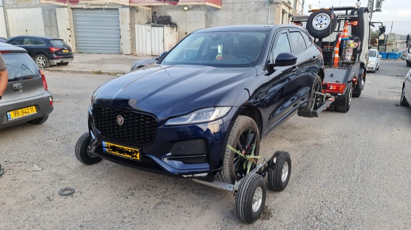 רכב יגואר כחול מורם על דולי גרירה