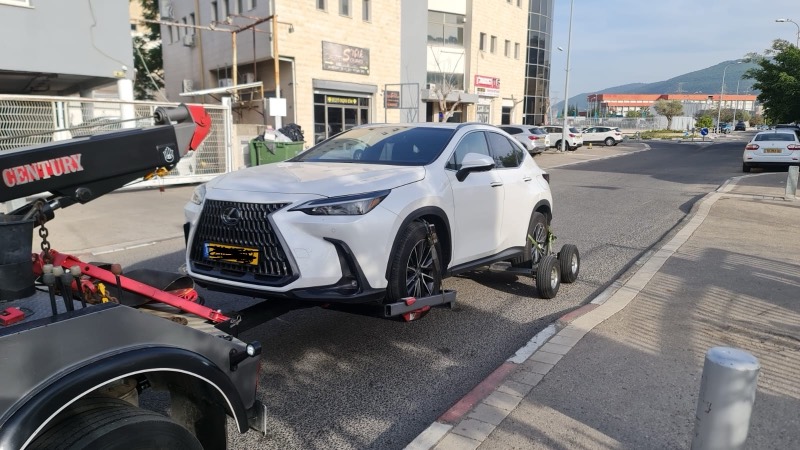 רכב לקסוס לבן מורם על דולי גרירה